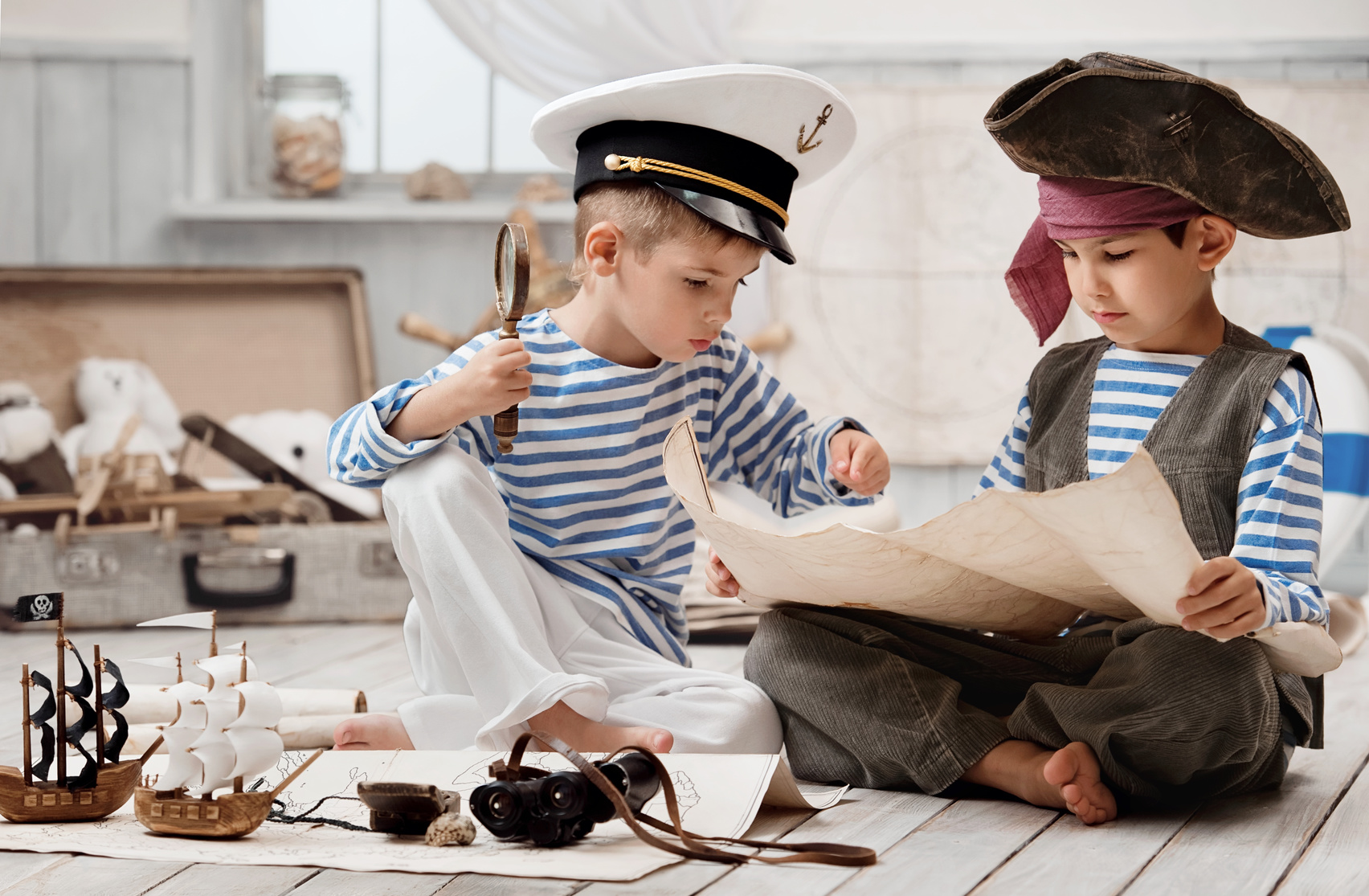 Boys dressed as a pirate captain and read travel map