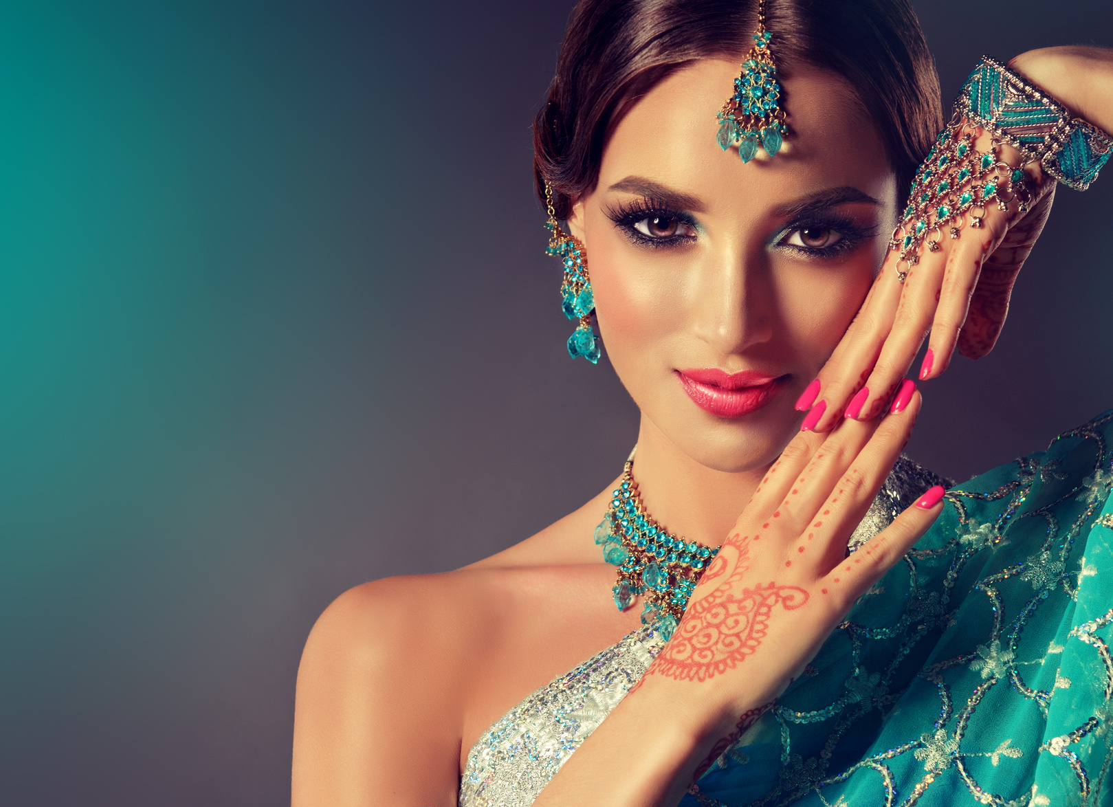 Portrait smiling of beautiful indian girl. Young indian woman model with blue kundan jewelry set . Traditional Indian costume .