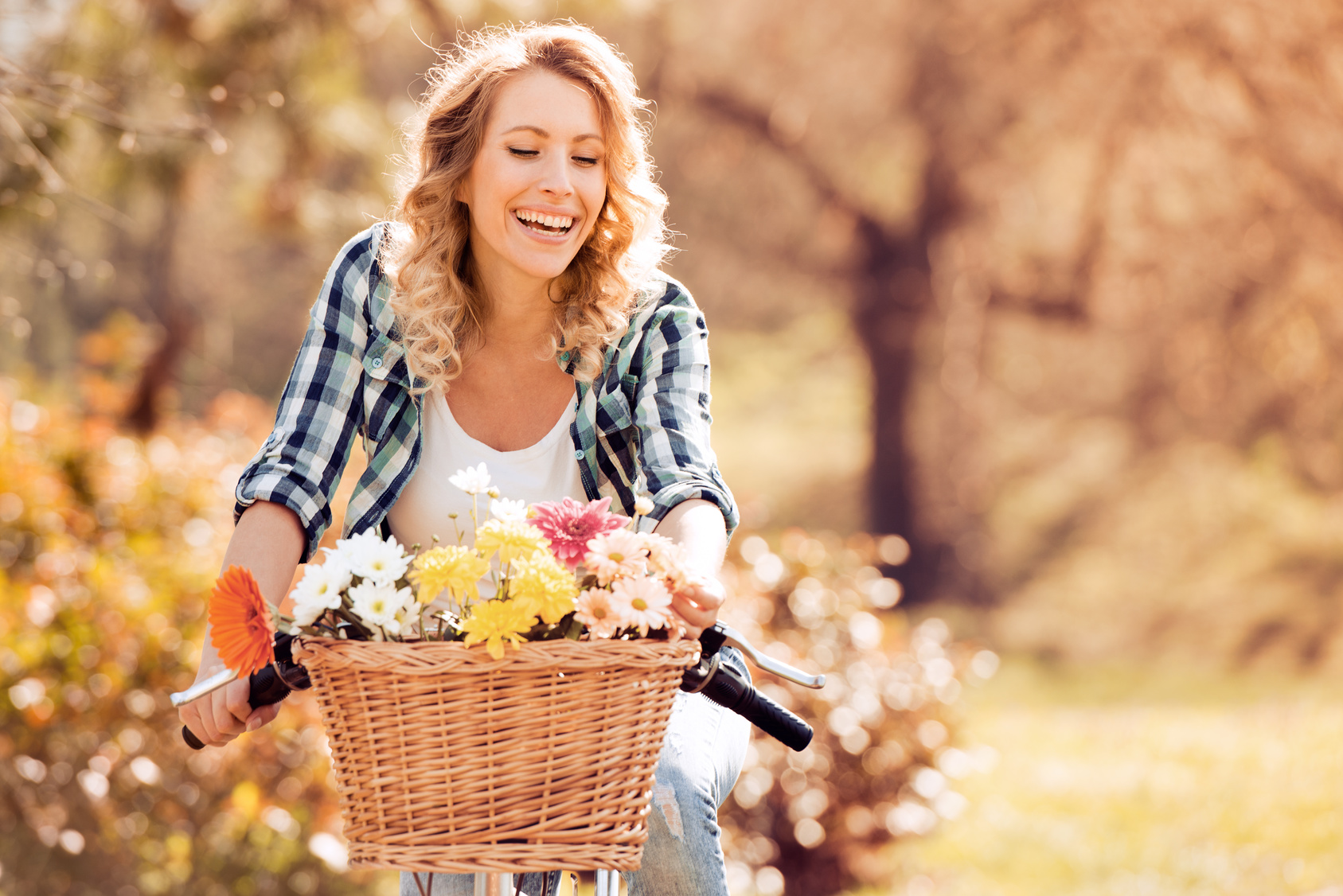 Beautiful smiling girl is riding the bicycle in the park.